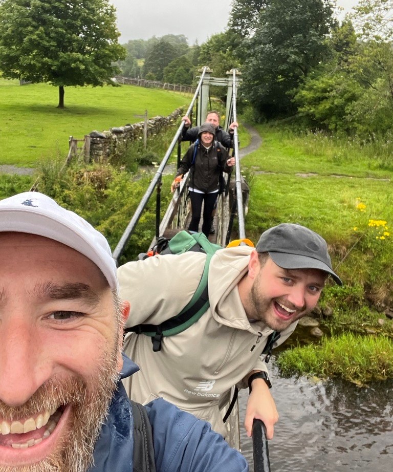 4 team members taking a picture on a bridge